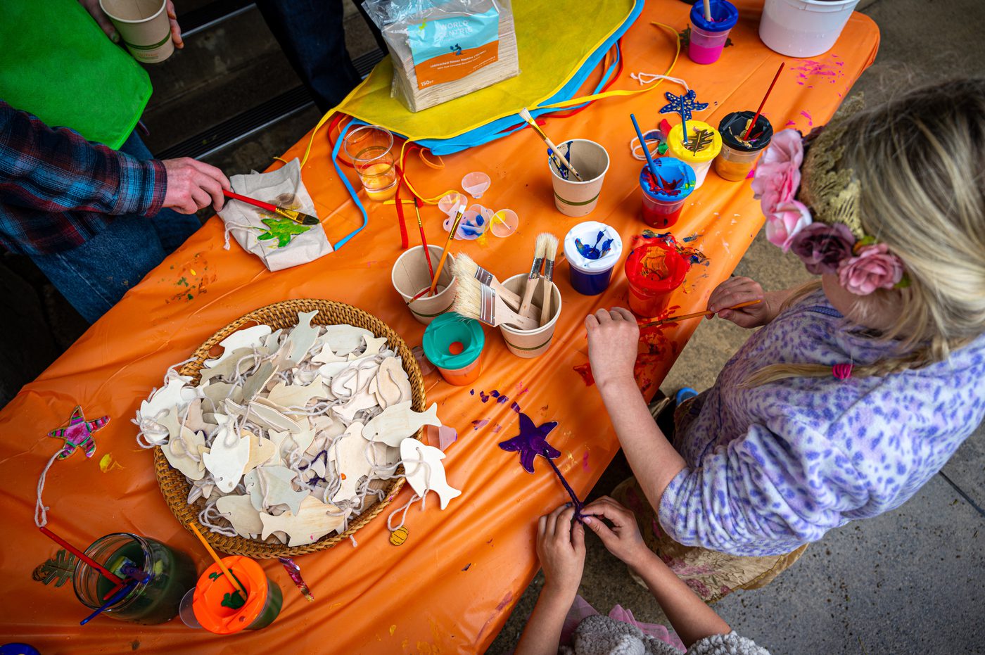 Children painting wooden ornaments at the craft table
